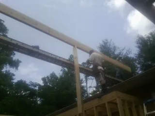 Carpenter setting a ridge beam over a new addition frame — Ice Dam Removal by Roofing Brothers in Altadena