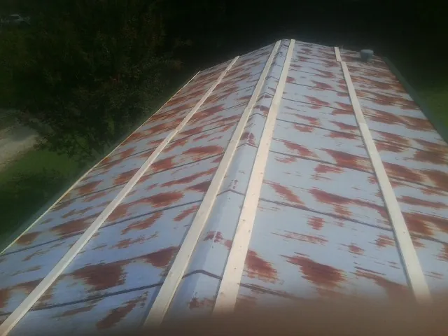 Rusted metal roof panels with new wood purlins before replacement — Storm Damage Roof Repair in Altadena by Roofing Brothers