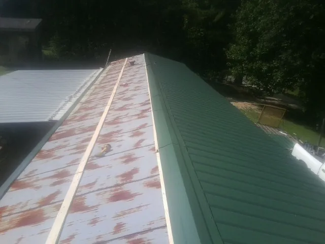 Old rusted panels beside newly installed green metal roofing — Wind Damage Roof Repair by Roofing Brothers in Altadena