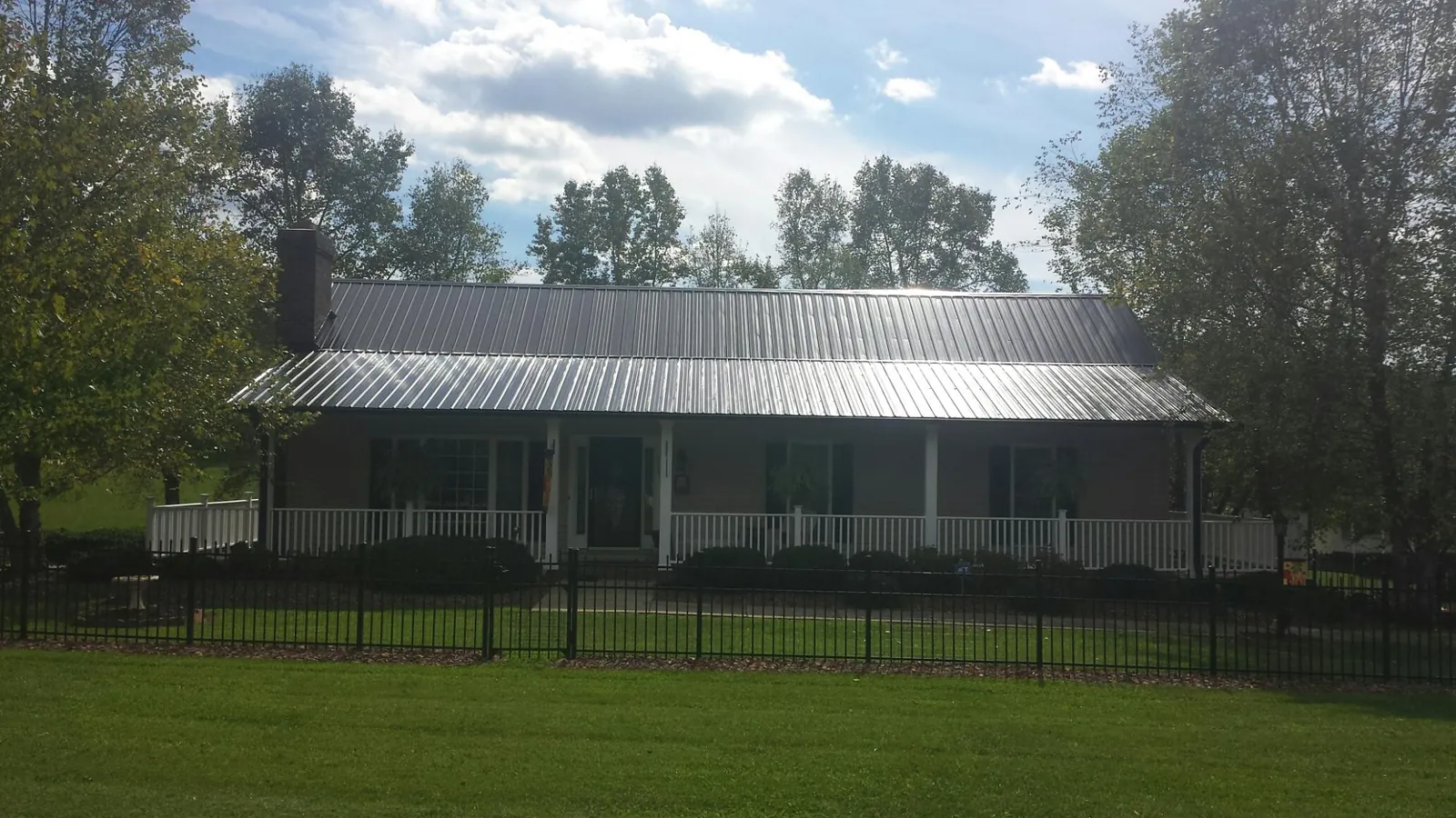 Gray metal roof on a brick ranch with a full width front porch — Gutter Guard Installation work by our crew in Altadena